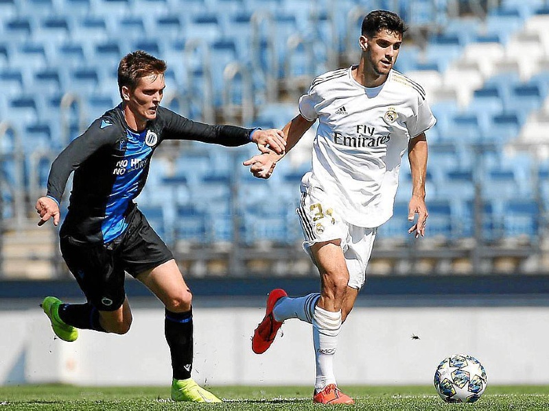 Real Madrid player Xavi Sintes holds off Club Brugge player